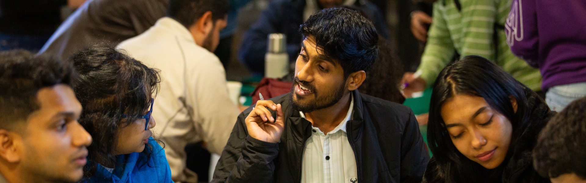 UCD alumni engaged in a discussion around a table.